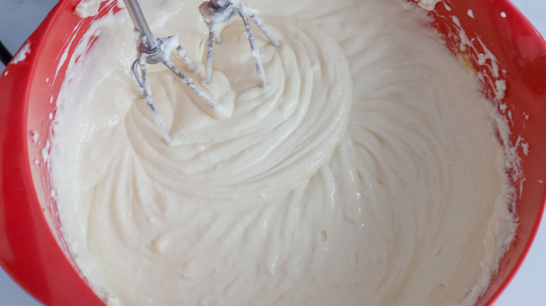 white batter in bowl with beaters