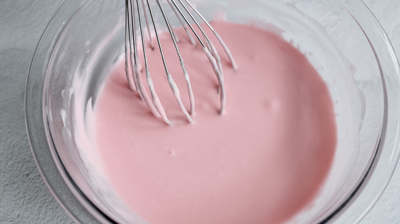 whisking pink glaze in bowl