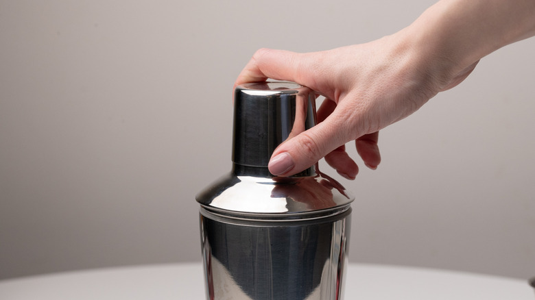 placing lid on cocktail shaker