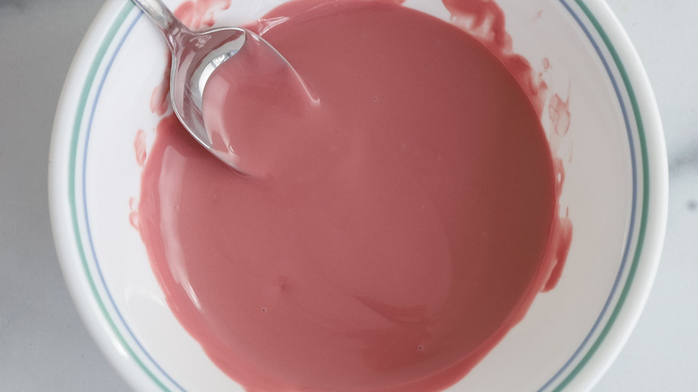 pink frosting in white bowl