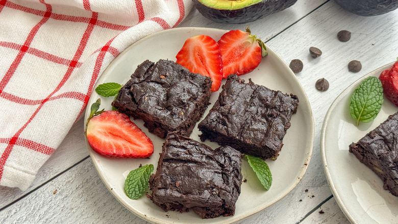 vegan avocado brownies on plate with strawberries