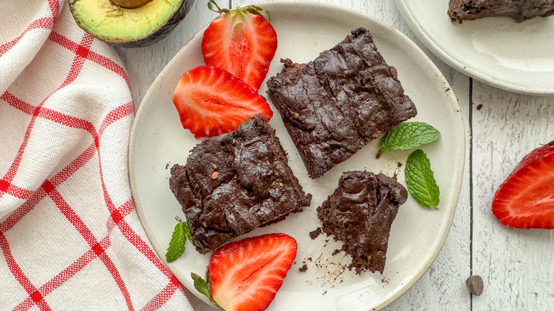 vegan avocado brownies on plate with strawberries