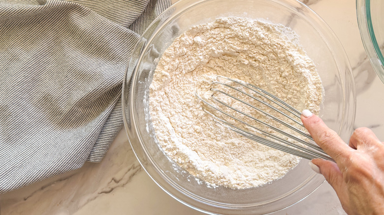 hand with whisk in bowl