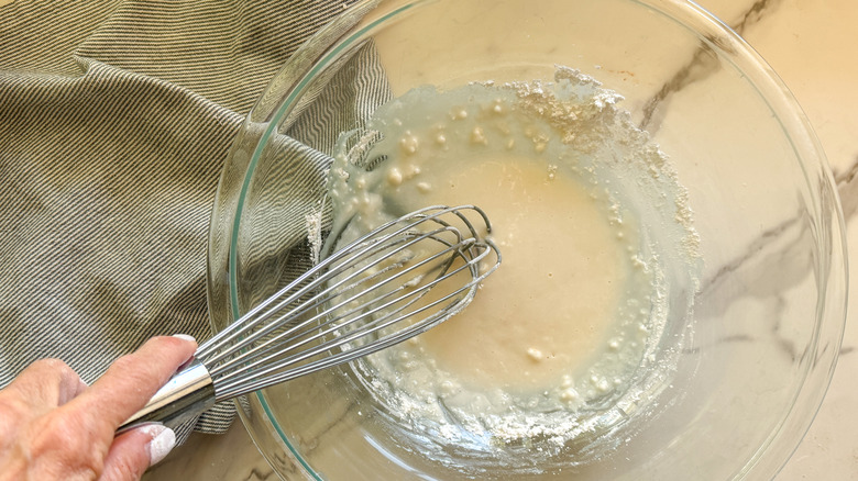 hand whisking batter in bowl