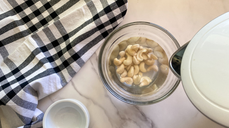 cashews in small bowl covered in water