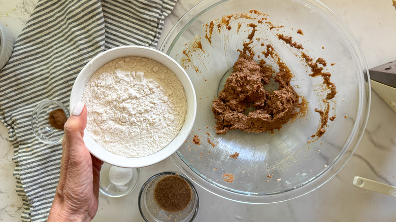 adding flour to bowl