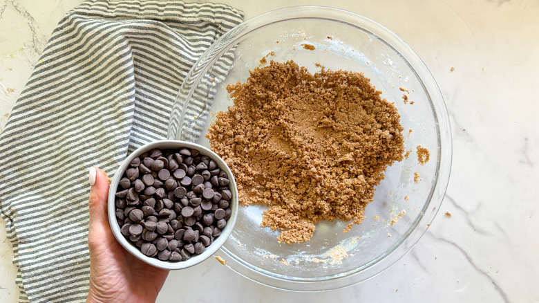 adding chocolate chips to bowl