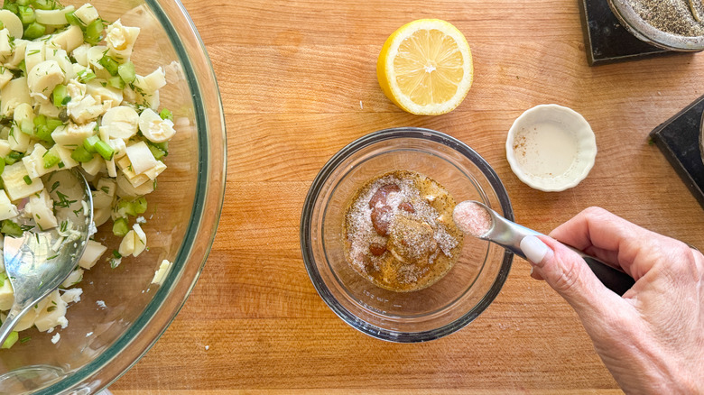 hand adding salt to bowl