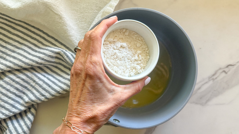 hand adding flour