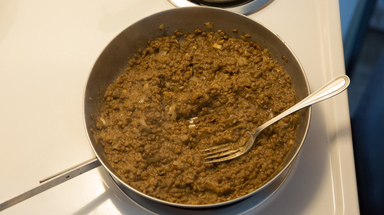 fork-mashed lentils in pan 