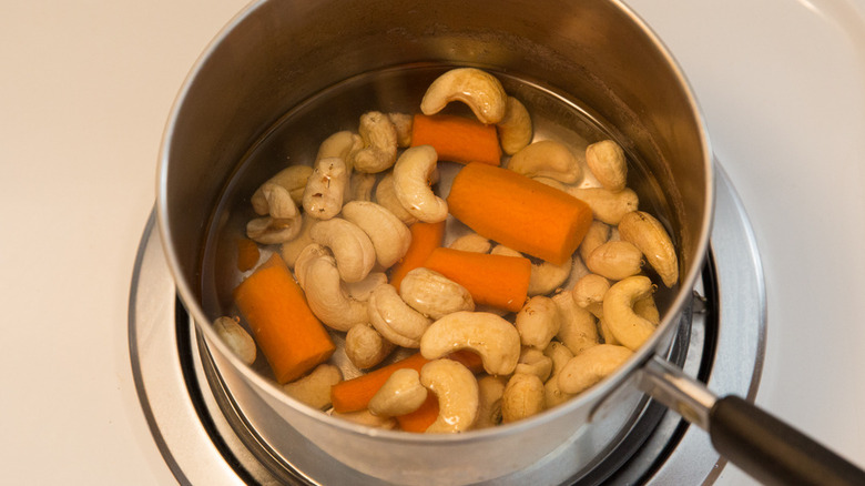 cashews and carrot cooking in saucepan 