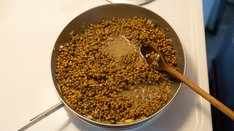 brown lentils cooking in pan 