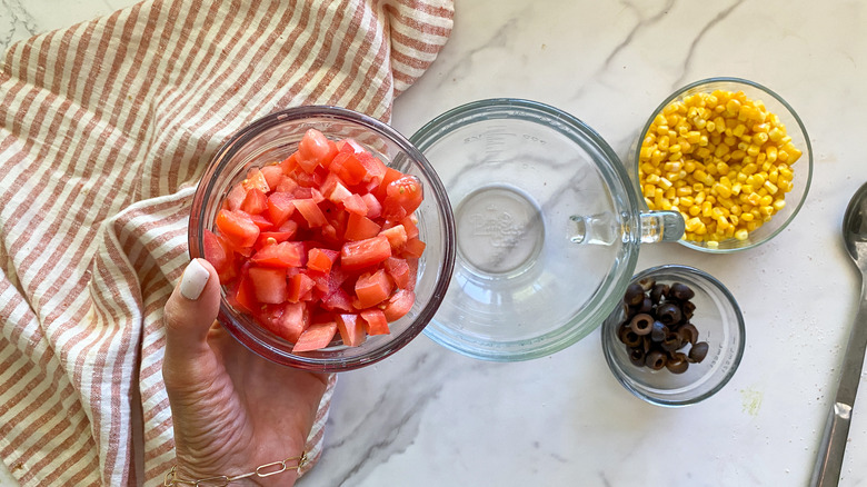 adding tomatoes to bowl