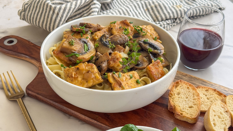 Tempeh Marsala in a white bowl next to crostini