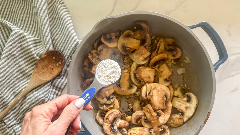 Hand adding  flour to pan or Marsala sauce