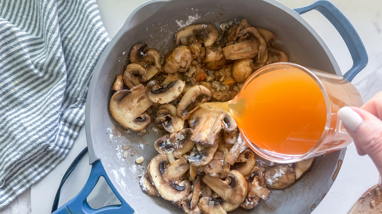 Hand pouring Marsala wine into pan