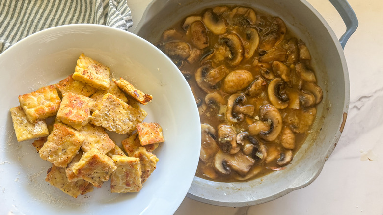 Adding tempeh to pan of mushroom sauce