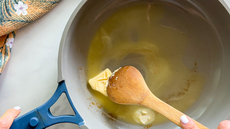 Butter and wooden spoon in pan