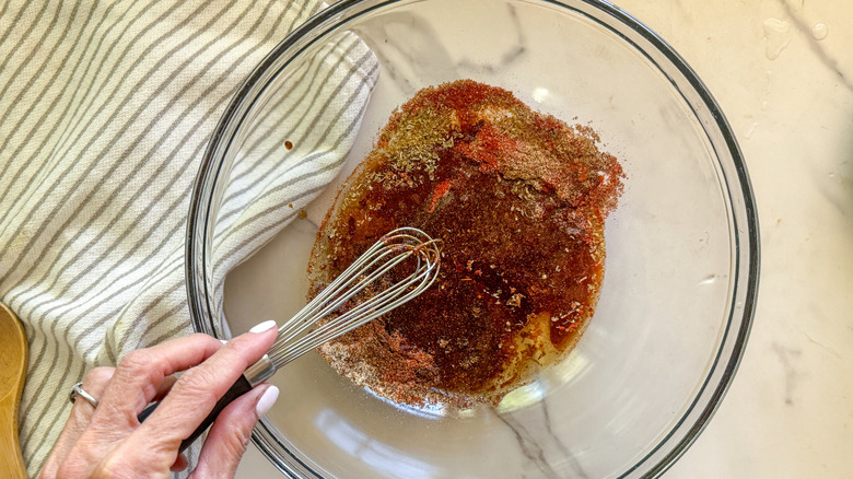 hand mixing marinade with whisk