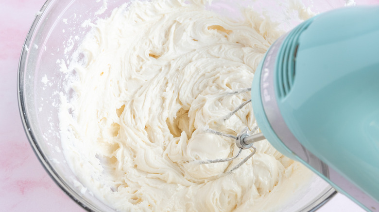 mixing frosting with a hand mixer