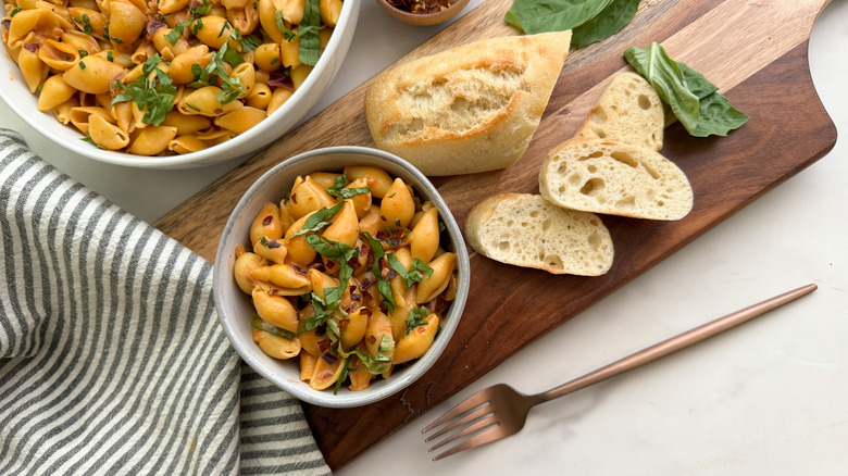 vodka sauce shell pasta served in bowls with basil and bread