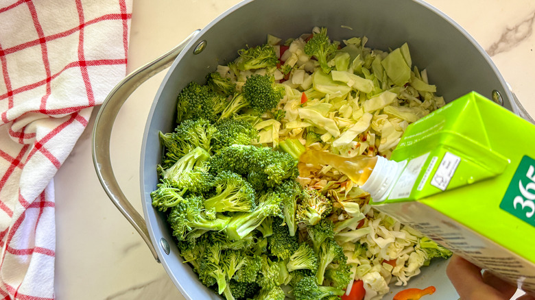 adding broth to pot