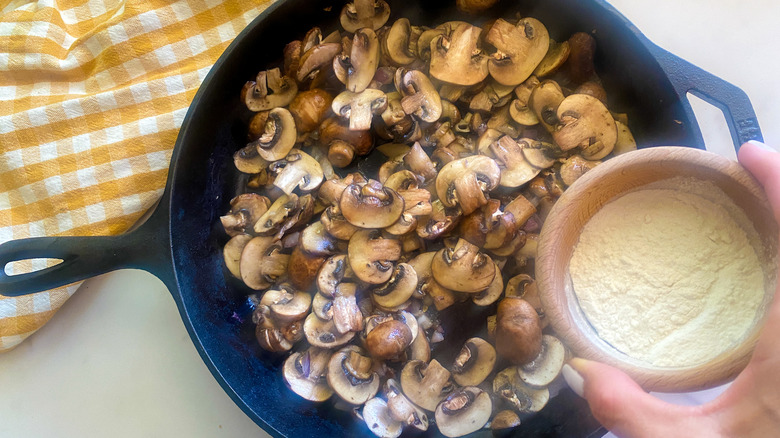 adding flour to mushrooms