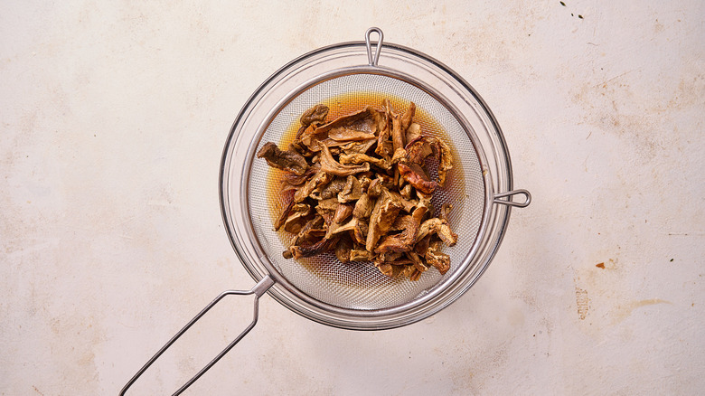 straining mushroom stock into bowl