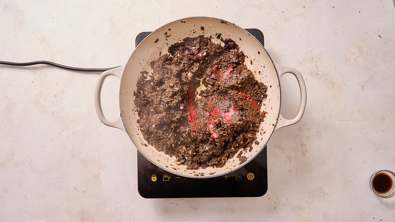 stirring tomato paste into skillet