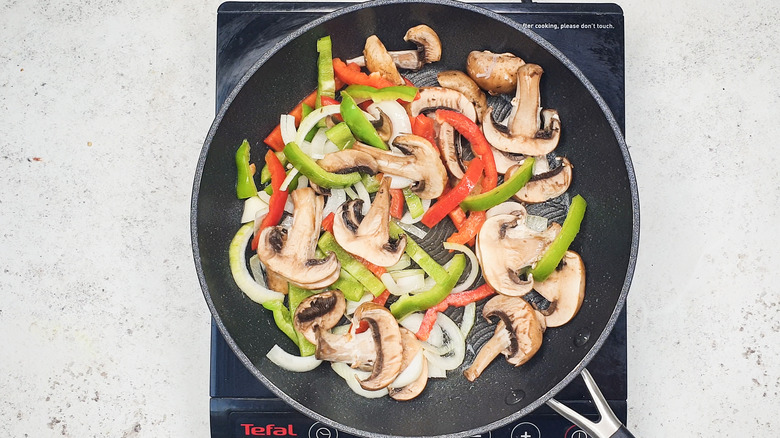 onion, pepper and mushrooms in pan