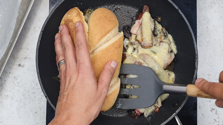 making cheesesteak sandwich