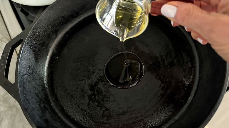 adding oil to skillet