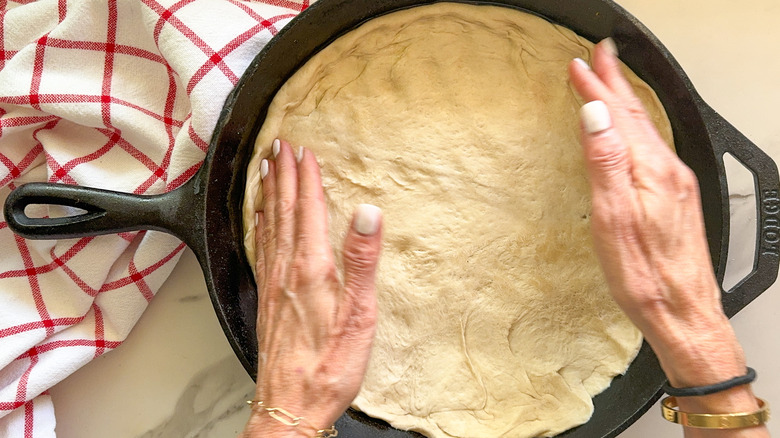 hands spreading out dough