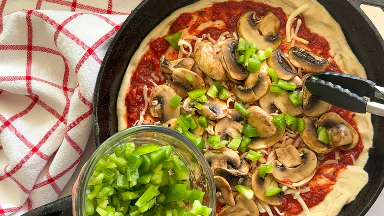 adding green pepper to pizza
