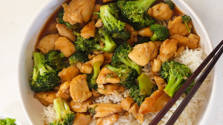 chicken and broccoli in a bowl with chopsticks