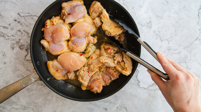 Flipping chicken in pan