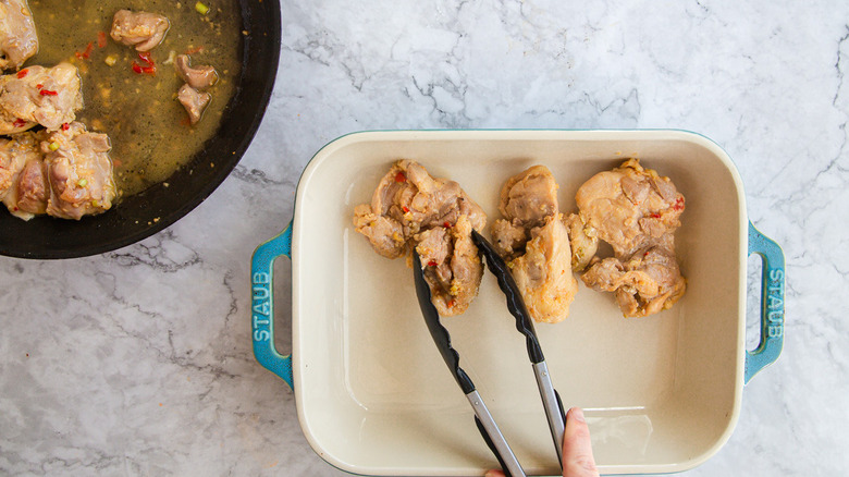 Transferring chicken to baking dish