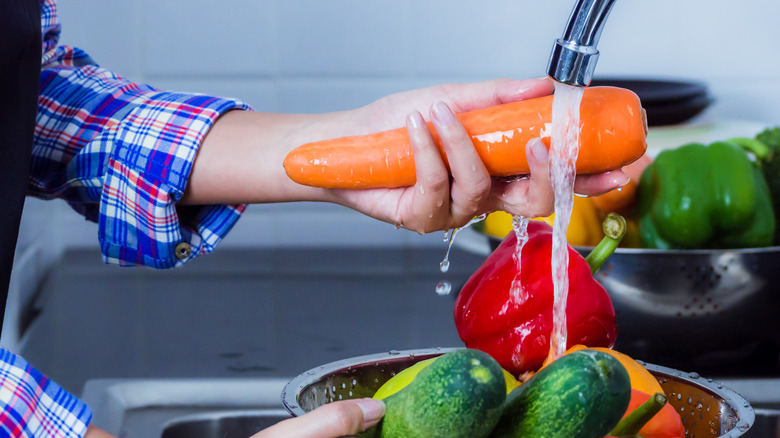 Person washing produce in sink