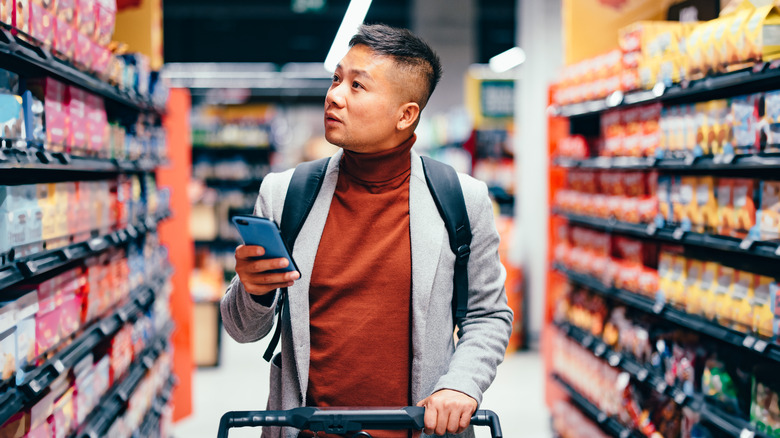 man looking for something in supermarket