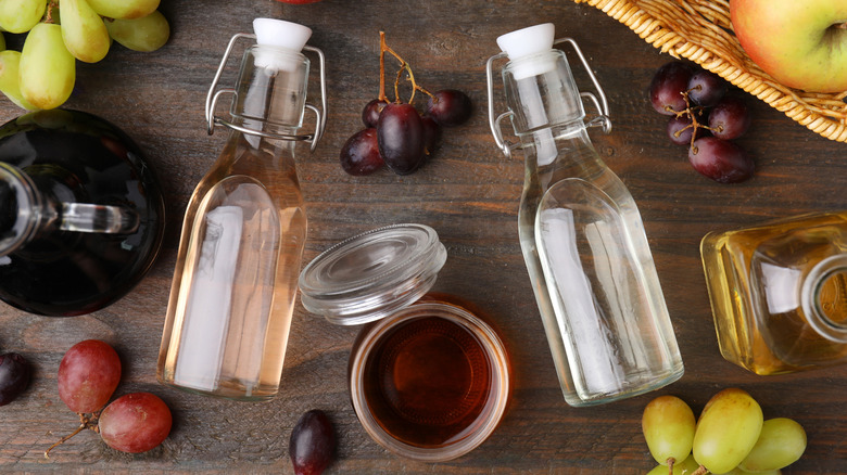 Bottles of vinegar and different fresh fruits