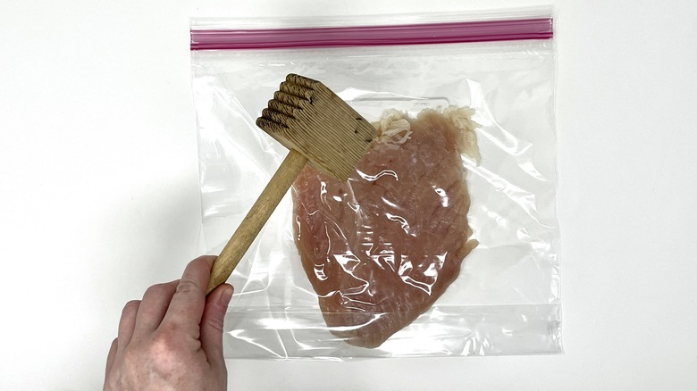 mallet pounding chicken in bag