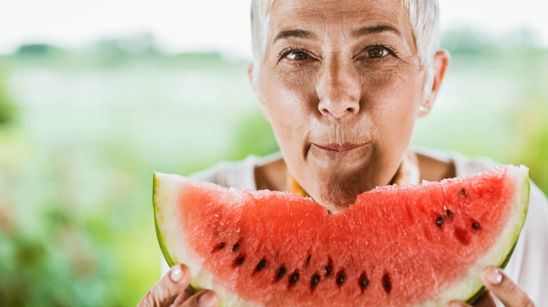 Woman eating large watermelon slice 