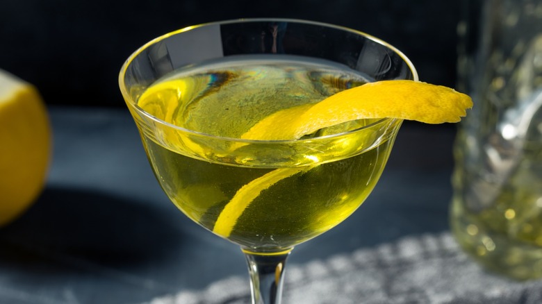 Close-up of a yellow Alaska cocktail with a lemon peel