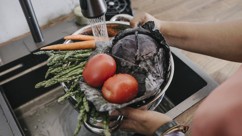 Person washing various vegetables 