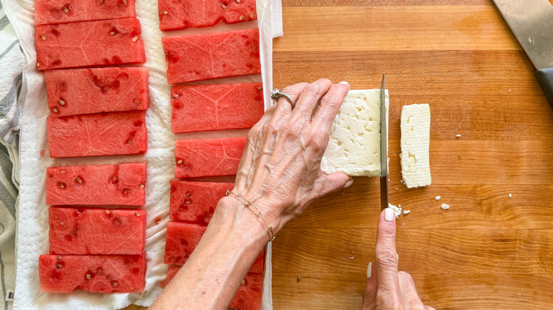 hand slicing cheese on board