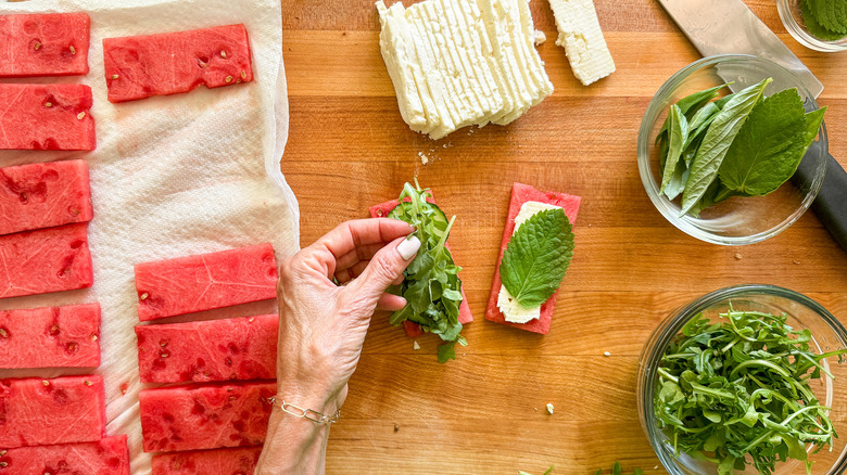 hand adding arugula