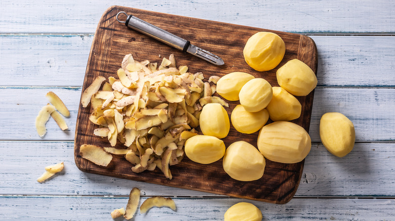 Peeled potatoes on cutting board