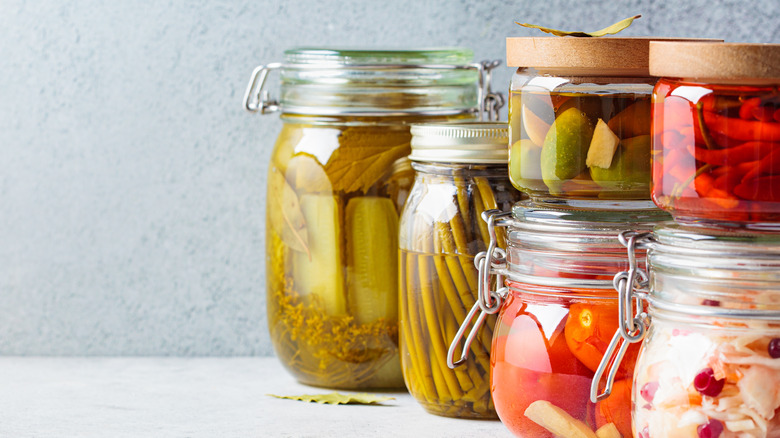 A bunch of glass jars containing pickles