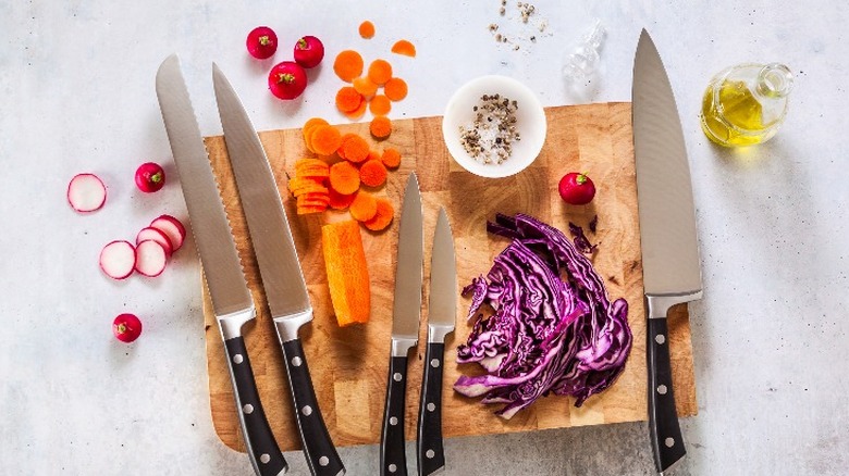 kitchen knives and vegetables on board