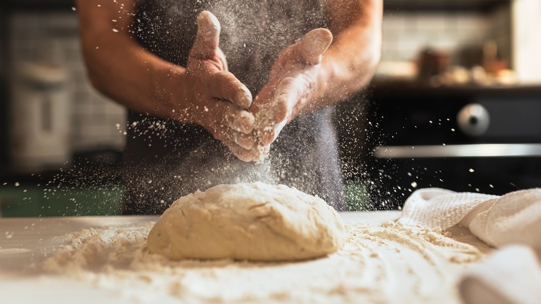 Hands dusting homemade dough